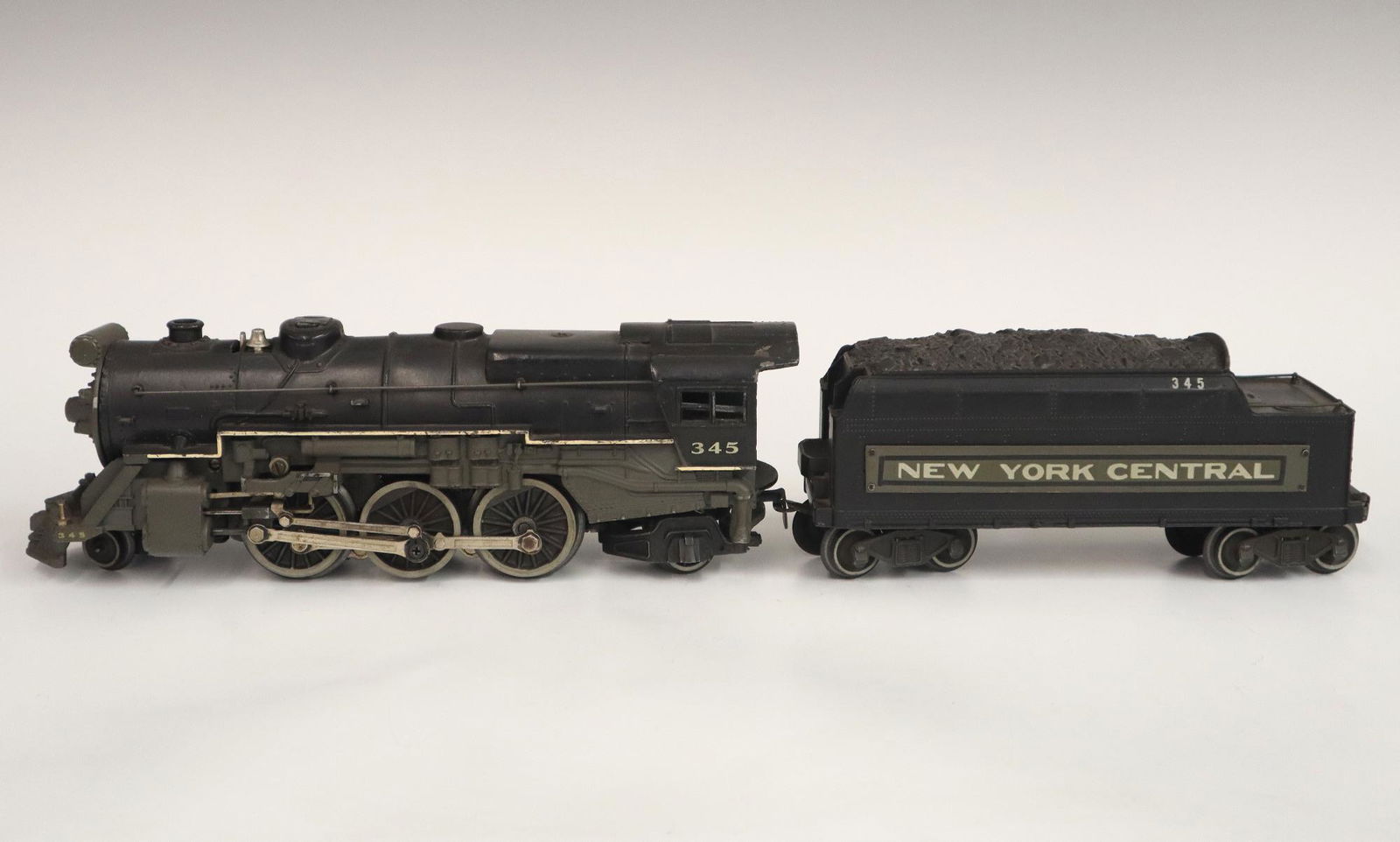 Lionel Locomotive and Tender: A Post-War Lionel O Gauge Locomotive #345 with Tender #345. Minor wear and soiling. 18" long. ESTIMATE $50-100