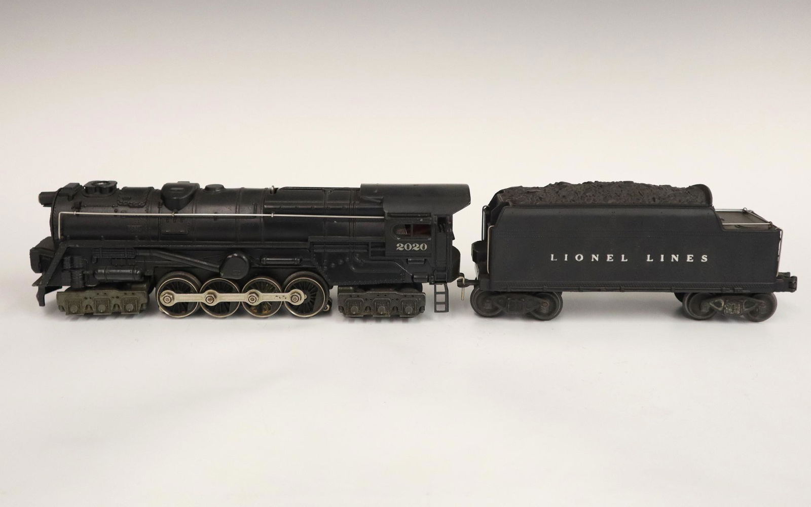 Lionel Locomotive and Tender: A Post-War Lionel O Gauge Locomotive #2020 with Tender #2020W. Minor wear and soiling. 18 1/2"long. ESTIMATE $50-100