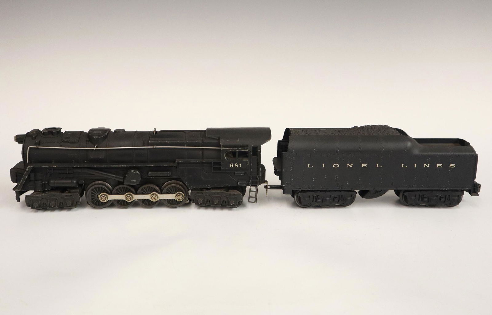 Lionel Locomotive and Tender: A Post-War Lionel O Gauge Locomotive #681 with Tender #2671WX. Minor wear and soiling. 19" long. ESTIMATE $50-100
