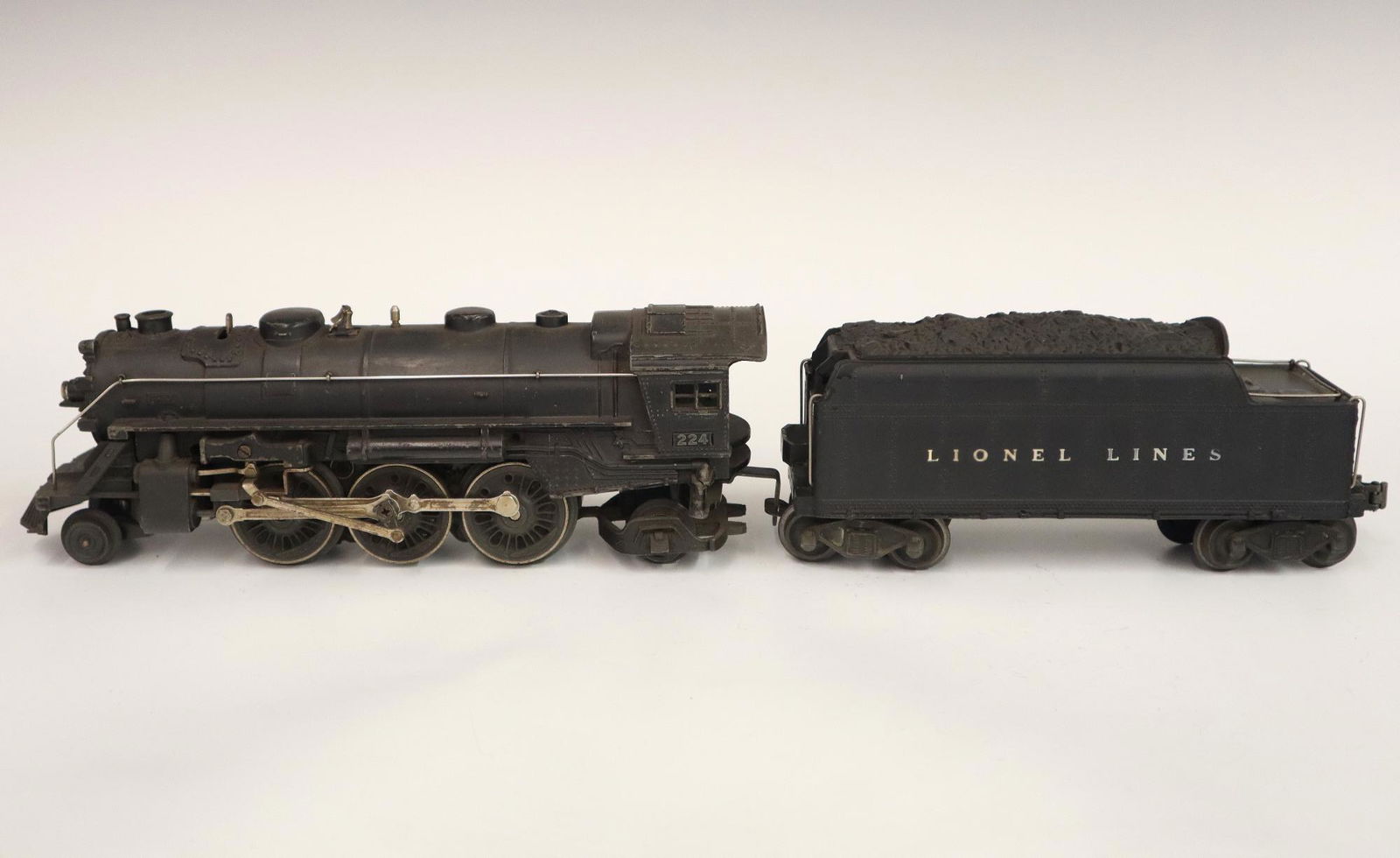 Lionel Locomotive and Tender: A Post-War Lionel O Gauge Locomotive #224 with Original Tender. Minor wear and soiling. 18" long overall. ESTIMATE $50-100