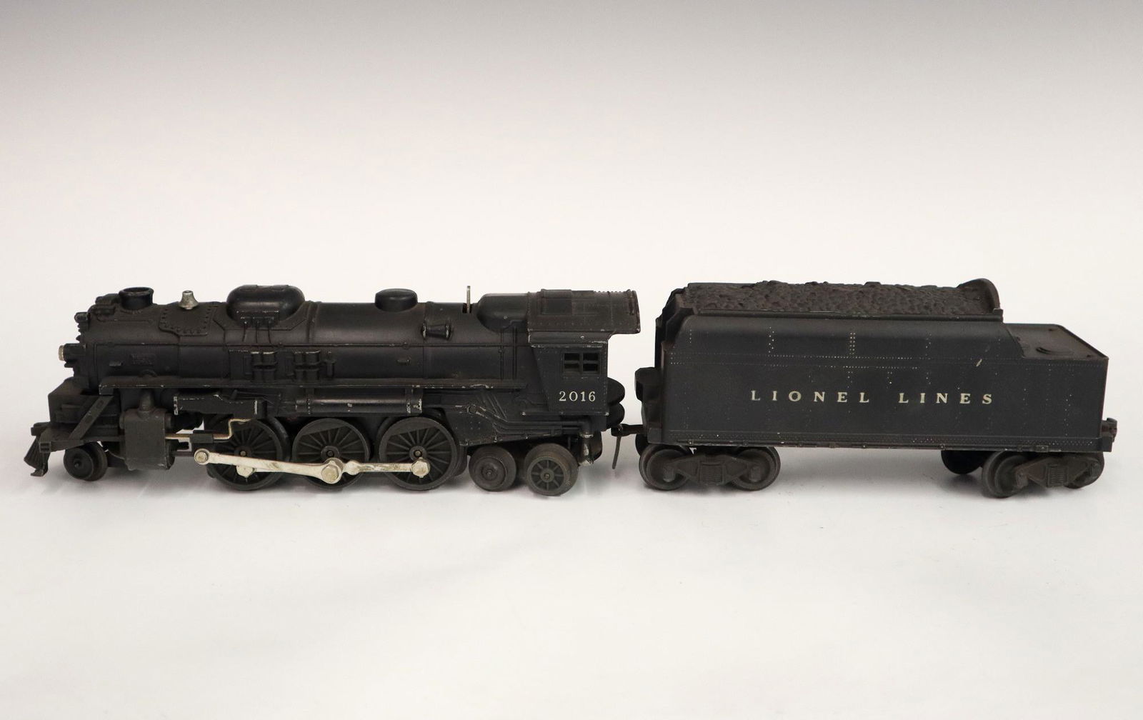 Lionel Locomotive and Tender: A Post-War Lionel O Gauge Locomotive #2016 with Tender #6466T. Minor wear and soiling. 17 1/2" long overall. ESTIMATE $50-100