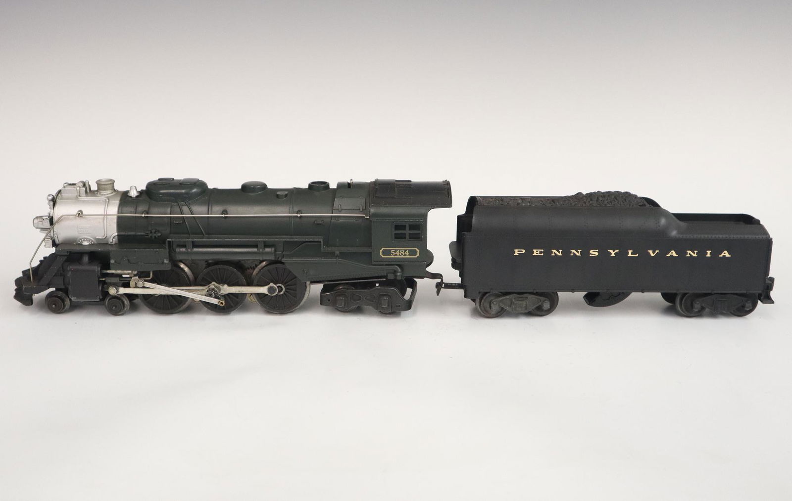 Lionel Locomotive and Tender: A Post-War Lionel O Gauge Locomotive #5484 with Tender #2046W. Locomotive is green, tender is black. Minor wear and soiling. 19 3/4" long. ESTIMATE $50-100