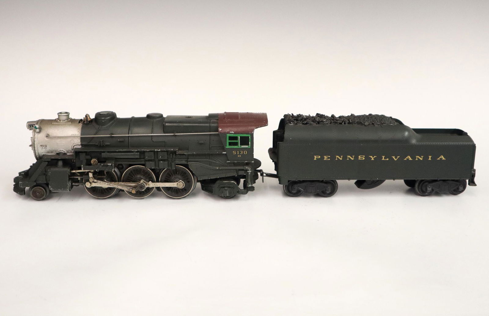 Lionel Locomotive and Tender: A Post-War Lionel O Gauge Locomotive #5130 with Tender #2046W. Both are green. Minor wear and soiling. 18 3/4" long. ESTIMATE $50-100