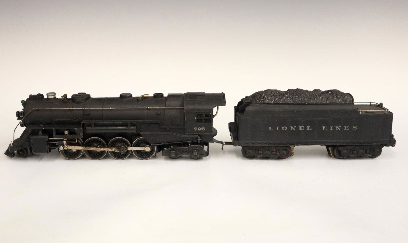 Lionel Locomotive and Tender: A Post-War Lionel O Gauge Locomotive #726 with Tender #2426W. Minor wear and soiling. 20 1/2" long. ESTIMATE $50-100