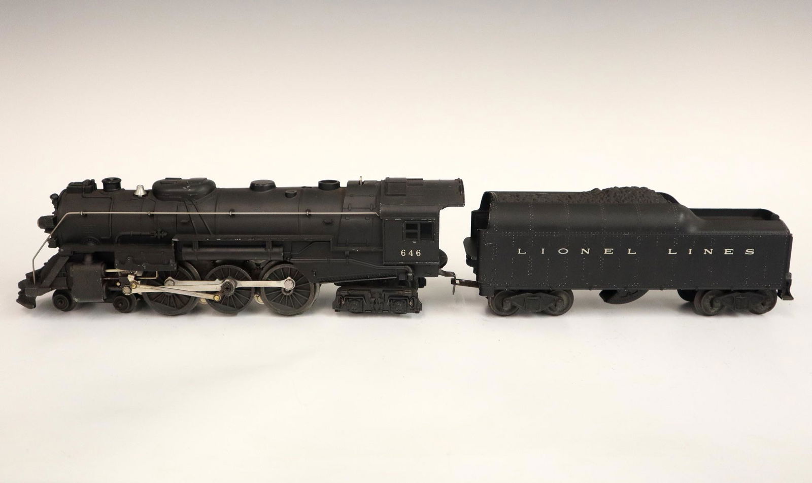 Lionel Locomotive and Tender: A Post-War Lionel O Gauge Locomotive #646 with Tender #2046W. Minor wear and soiling. 20" long overall. ESTIMATE $50-100