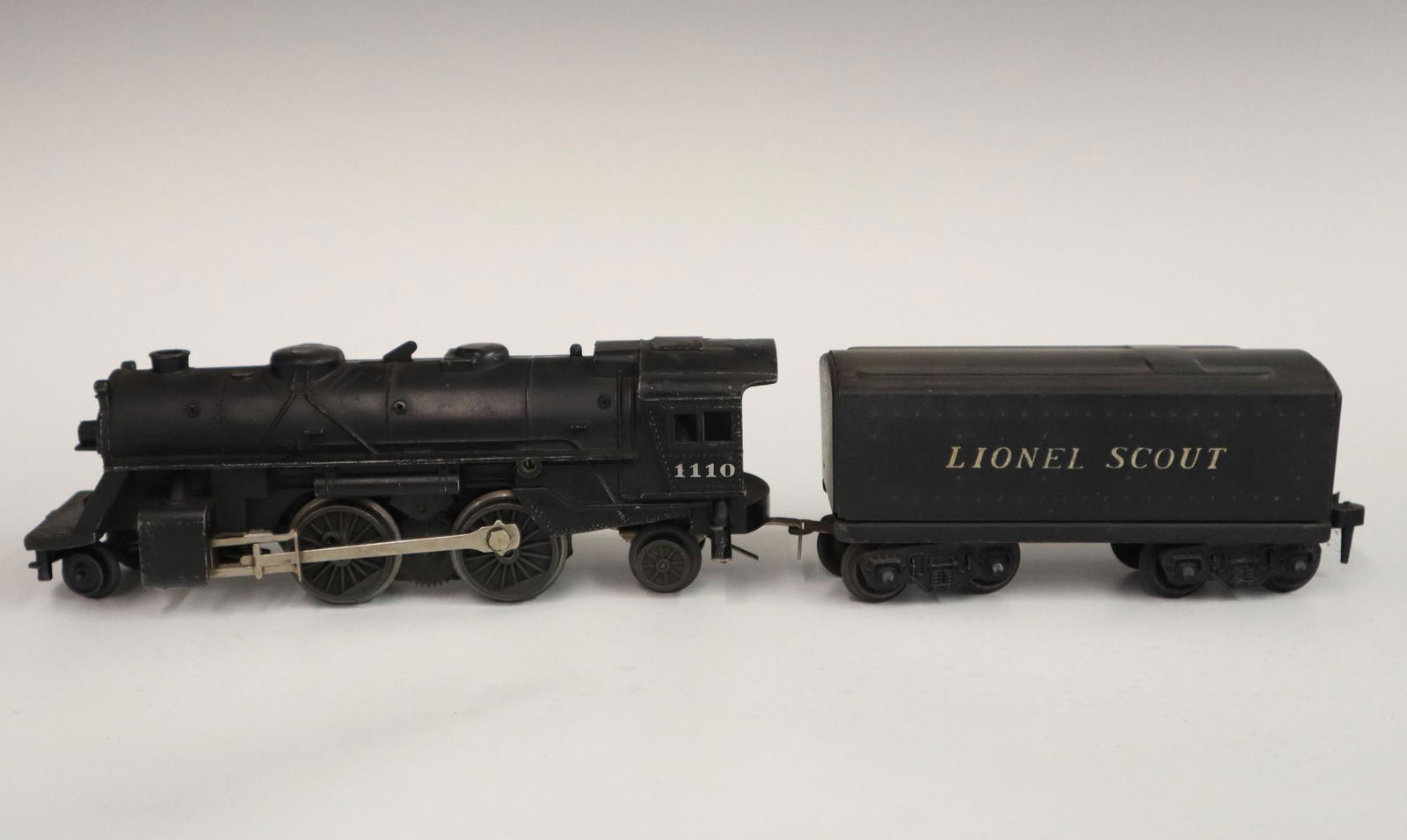Lionel Locomotive and Tender: A Post-War Lionel O Gauge Locomotive #1110 with Original Tender. Minor wear and soiling. 15 1/2" long overall. ESTIMATE $50-100