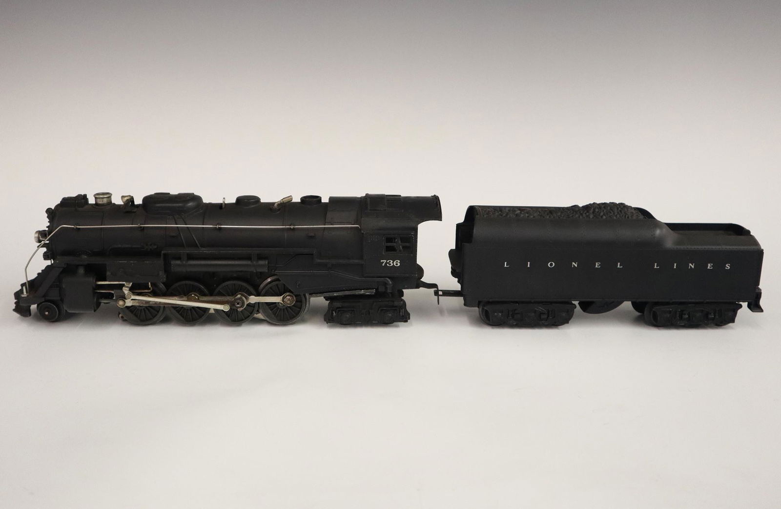 Lionel Locomotive and Tender: A Post-War Lionel O Gauge Locomotive #736 with Tender #2671WX. Minor wear and soiling. 20 1/4" long overall. ESTIMATE $50-100