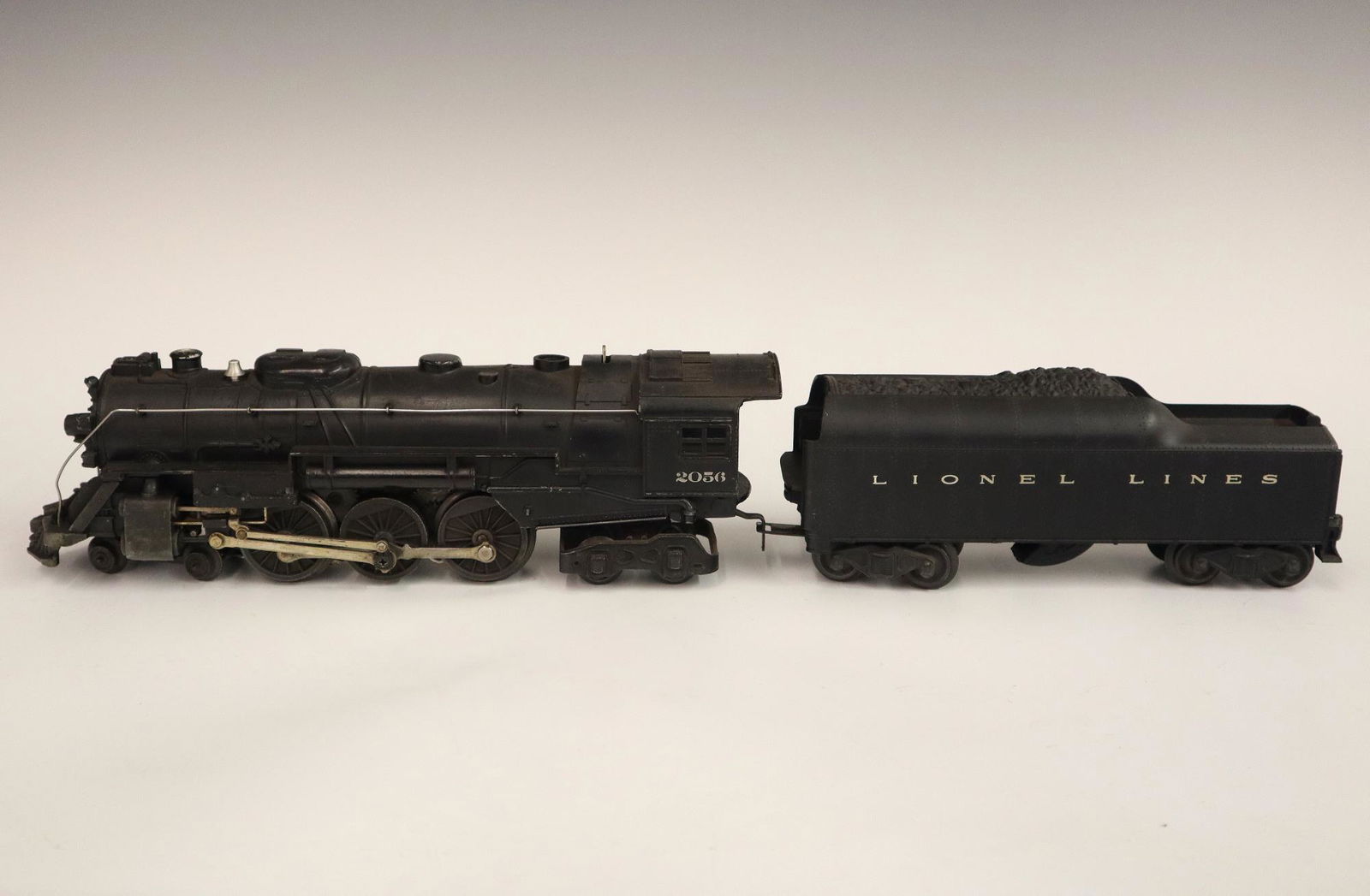 Lionel Locomotive and Tender: A Post-War Lionel O Gauge Locomotive #2056 with Tender #2046W. Minor wear and soiling. #20 1/4" long overall. ESTIMATE $50-100