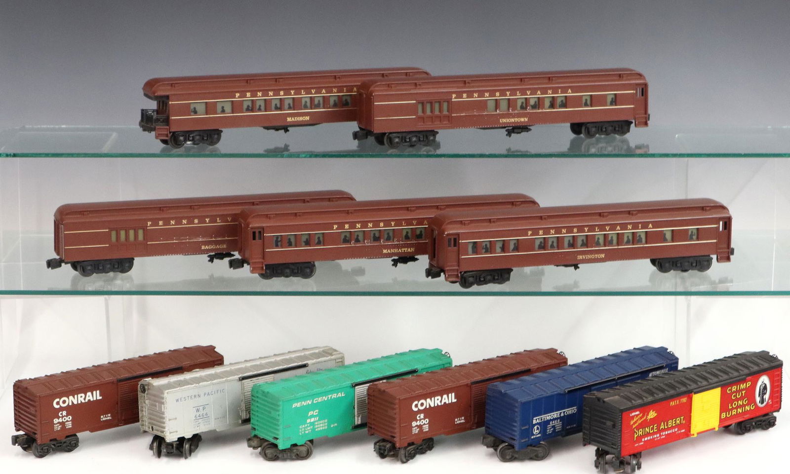 11 Lionel Train Cars: Eleven Post-War Lionel O Gauge Train Cars. Including 7 box cars and 5 passenger cars. Minor wear and soiling. Up to 14" long. ESTIMATE $50-100