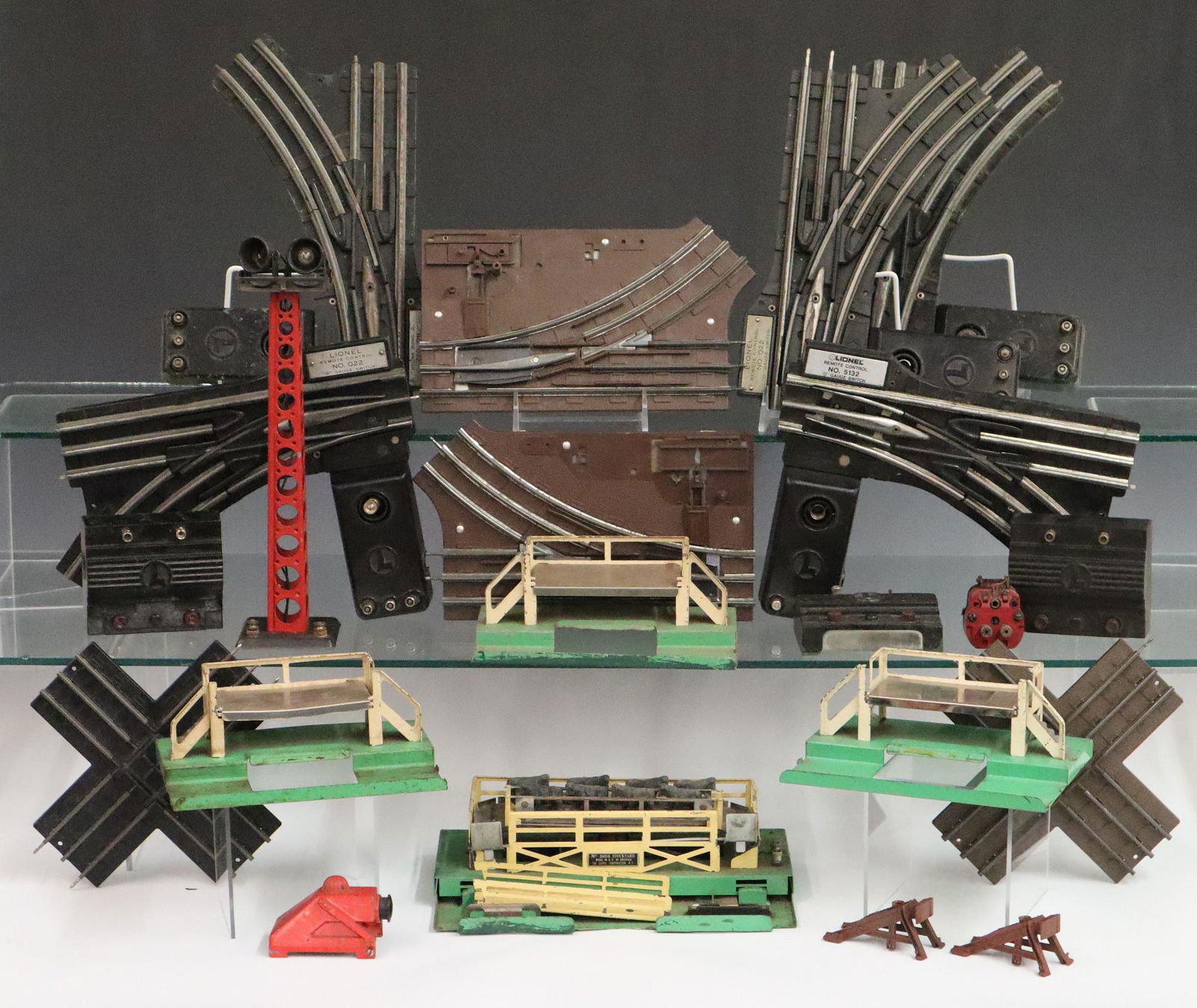 Lionel Track, Controls, & Misc. Pieces: Lot of Assorted Post-War Lionel Track, Controls & Pieces. Includes 4 #O22 0 Gauge remote controls, a #671-75 smoke lamp, a #260 bumper, a spotlight tower, a #5132 0 gauge remote control, 3 milk car pl