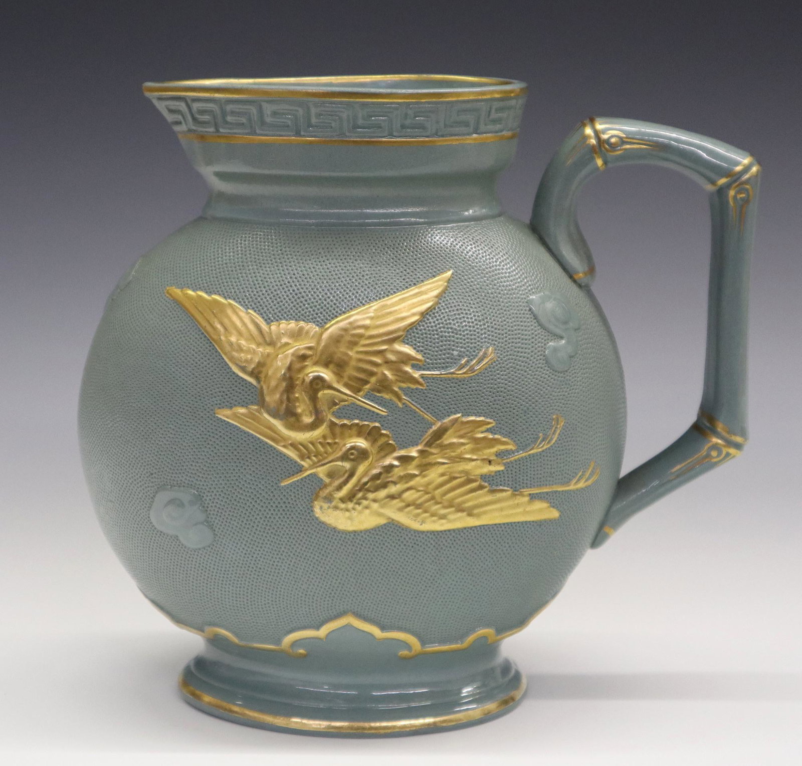 Brownfield & Son Jug: A 19th Century Aesthetic Perdio Brownfield & Son "Yeddo" Jug. Molded pitcher done in the Japonesque style with bamboo style handle, textured "orange skin" type ground and gilt cranes amidst clouds at