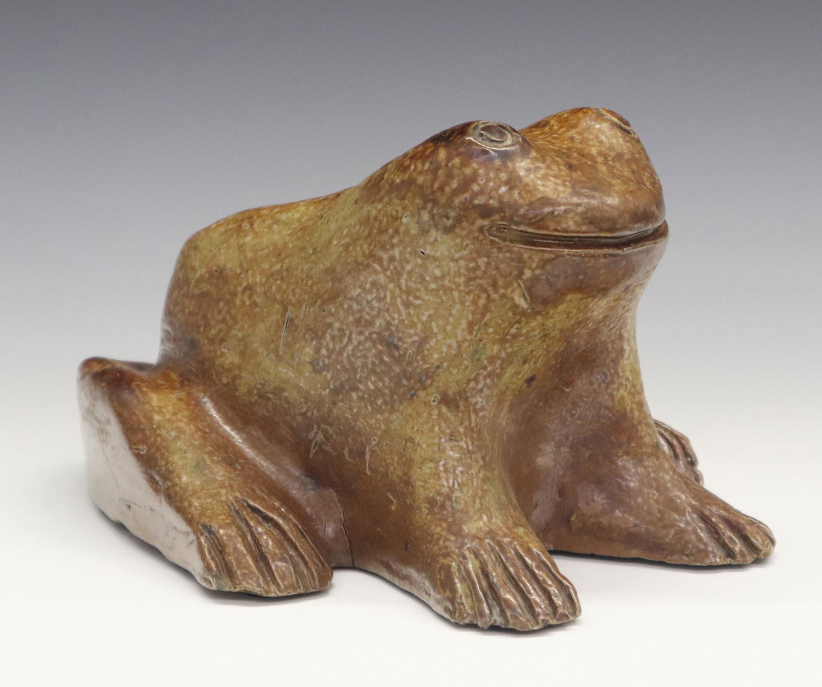 Redware Doorstop: A Late 19th to Early 20th Century Sewer Tile Frog Doorstop. With reddish brown glaze overall, incised "RLW" at the underside. Some firing cracks and small chips to the toes. 6 3/4 x 9 x 5 1/4" high. E
