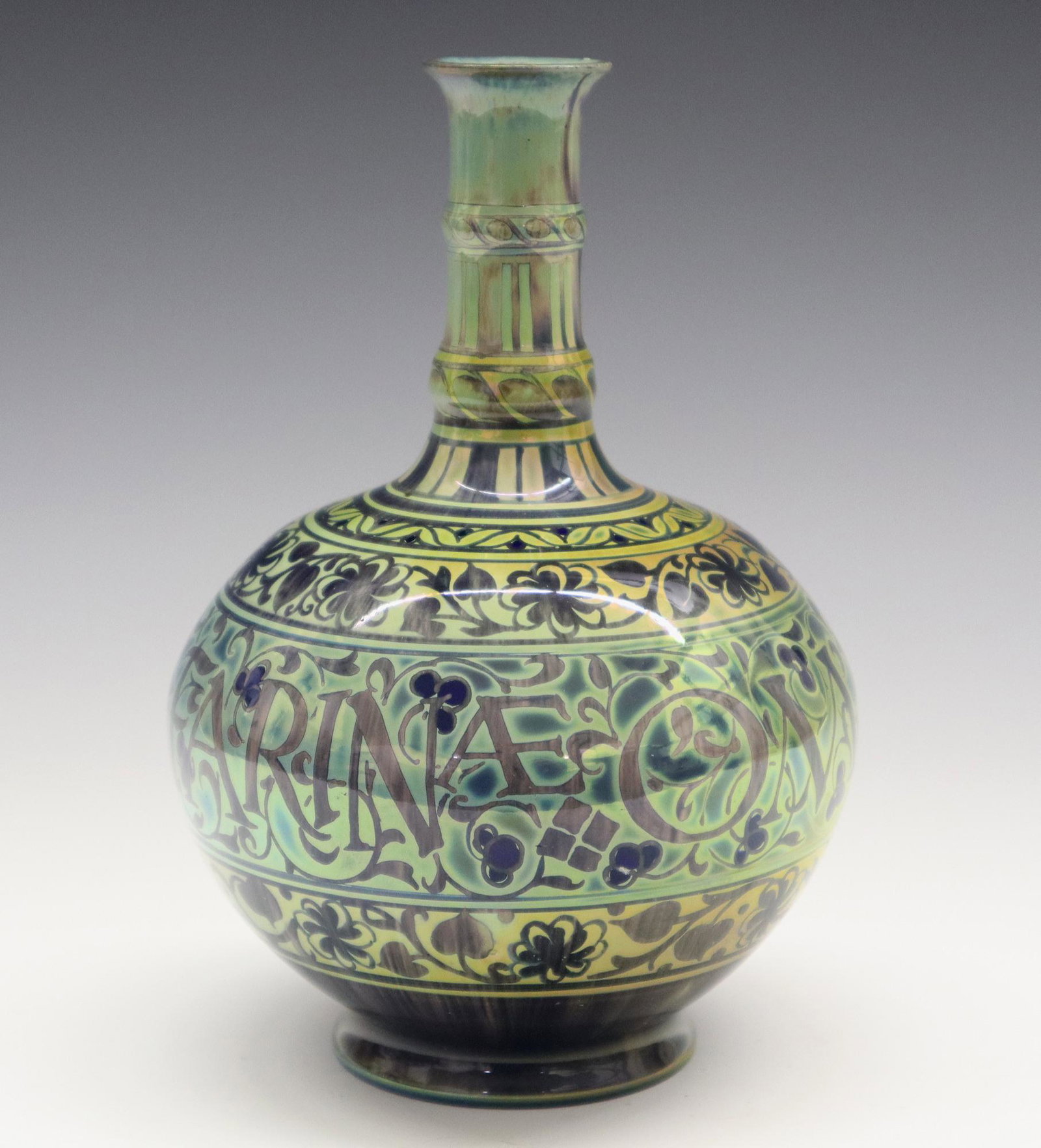 W. S. Mycock/Pilkington Vase: An Art Pottery Vase by William S. Mycock for Pilkington, 1913. A Royal Lancastrian bottle form vase with lustre glaze overall in dark blue, pale green, and gold is decorated with bands of floral, leaf