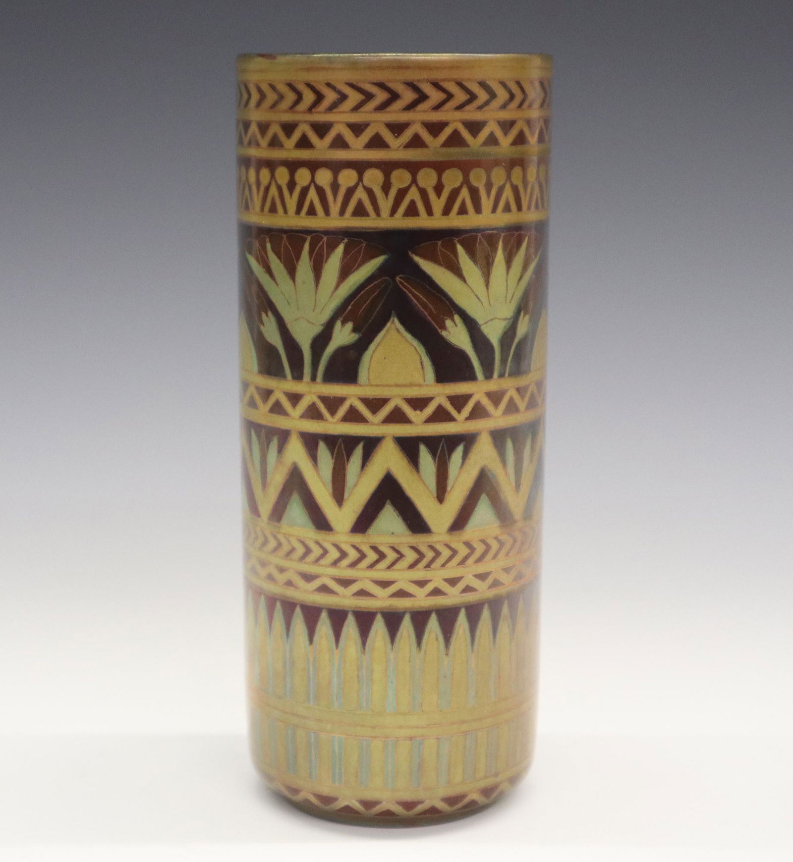 Zsolnay Pottery Vase: An Egyptian Revival Era Zsolnay Eosin Glazed Pottery Vase. Cylindrical Vase stylized with lustre glaze in gold, dark reddish brown, and hints of green forming registers with geometric and stylized flo