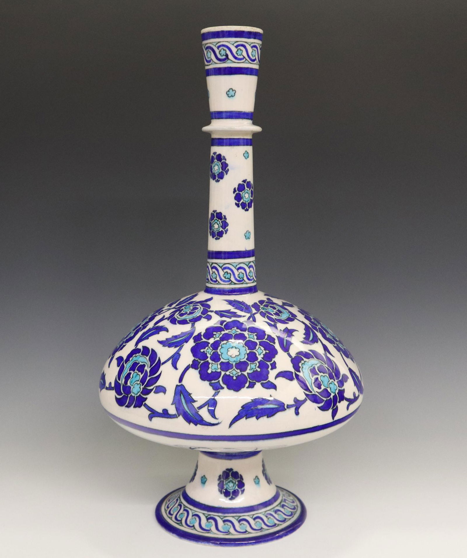 Th. Deck Bottle Form Vase: A Late 19th Century Theodore Deck Glazed Earthenware Vase. Bottle form vase done in the Iznik style, consists of a white ground with stylized flower and scrolling leaf and vine motifs overall, with gu
