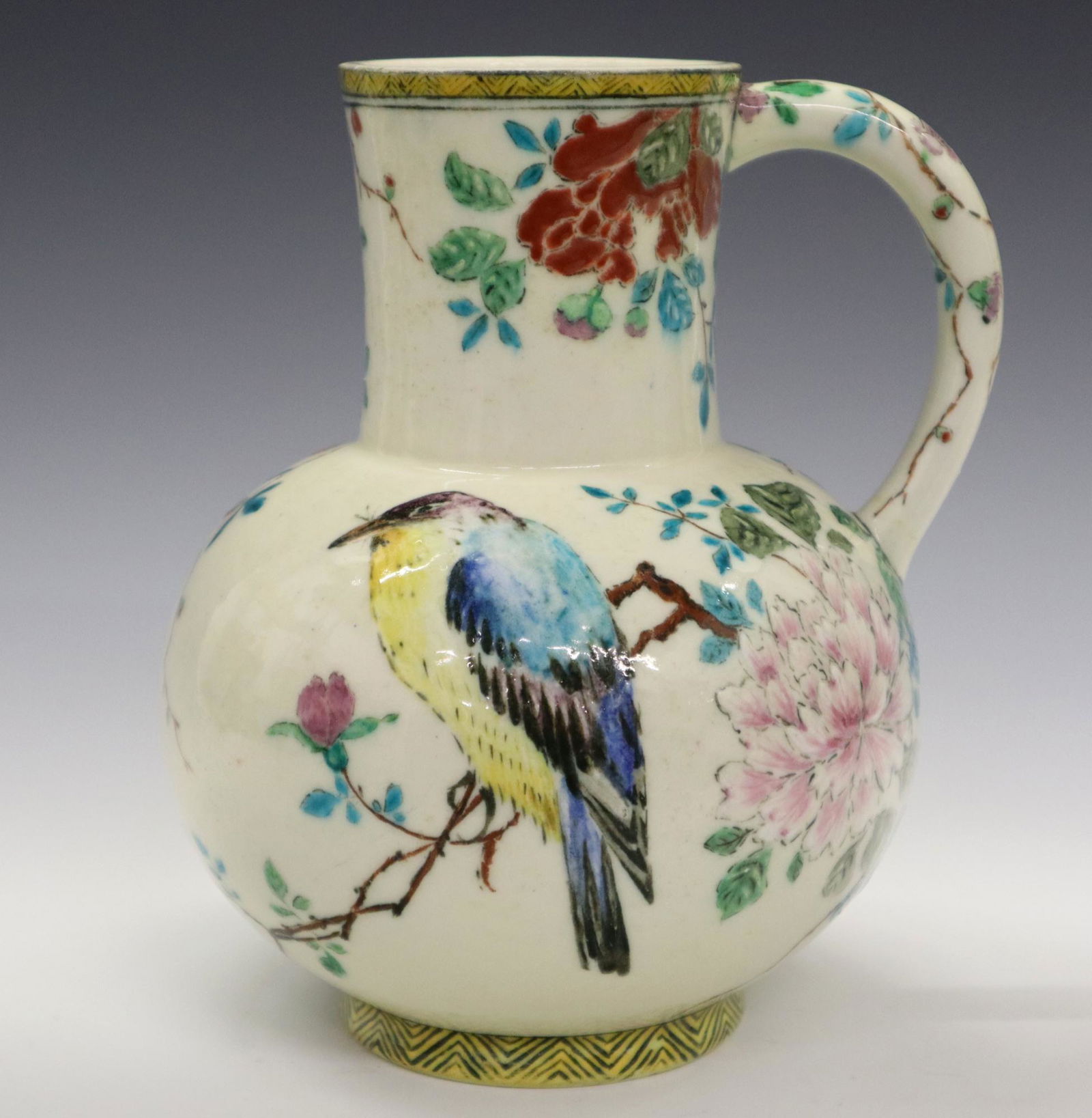Th. Deck Ewer: A 19th Century Theodore Deck Glazed Earthenware Ewer. Having a creamy white "orange peel" ground that is decorated with multi-colored floral, blossoming branch, bird, and butterfly motifs. Marked "TH.