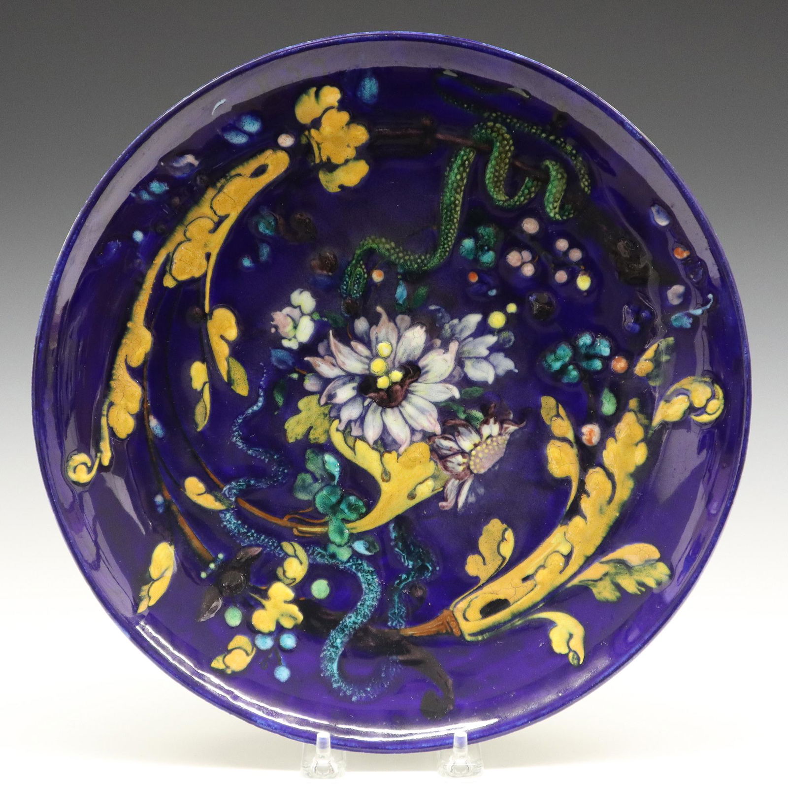 Th. Deck Charger: A 19th Century Theodore Deck Glazed Earthenware Charger. Round charger with cobalt ground that is decorated with goldenrod leaves, white to lavender flowers, two writhing snakes, one green and one tur