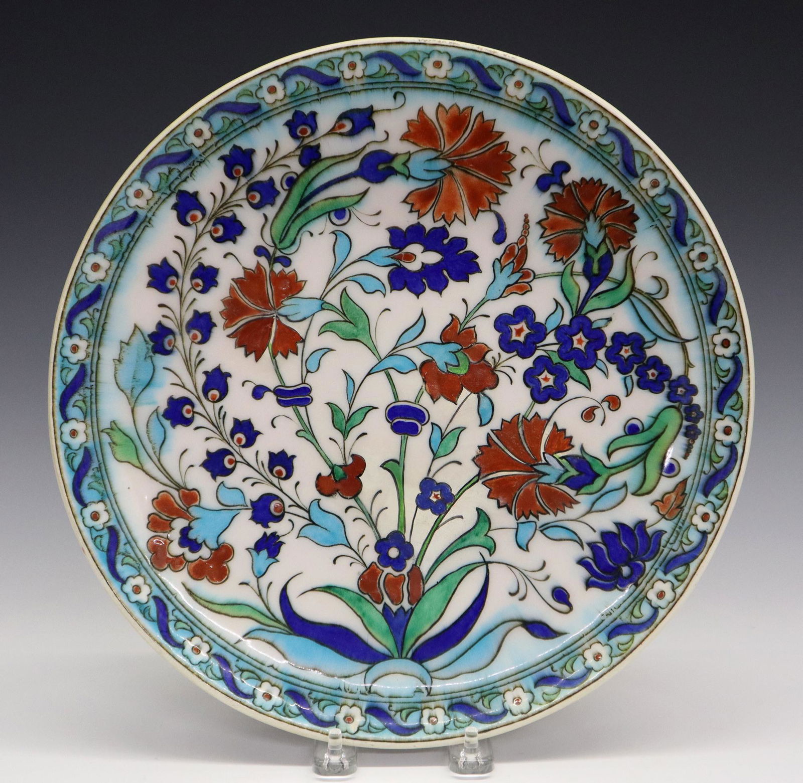 Th. Deck Charger: A Late 19th Century Theodore Deck Glazed Earthenware Charger. Round charger decorated in the Iznik style consisting of a white ground with red and azure blue stylized flowers, and green and blue leave