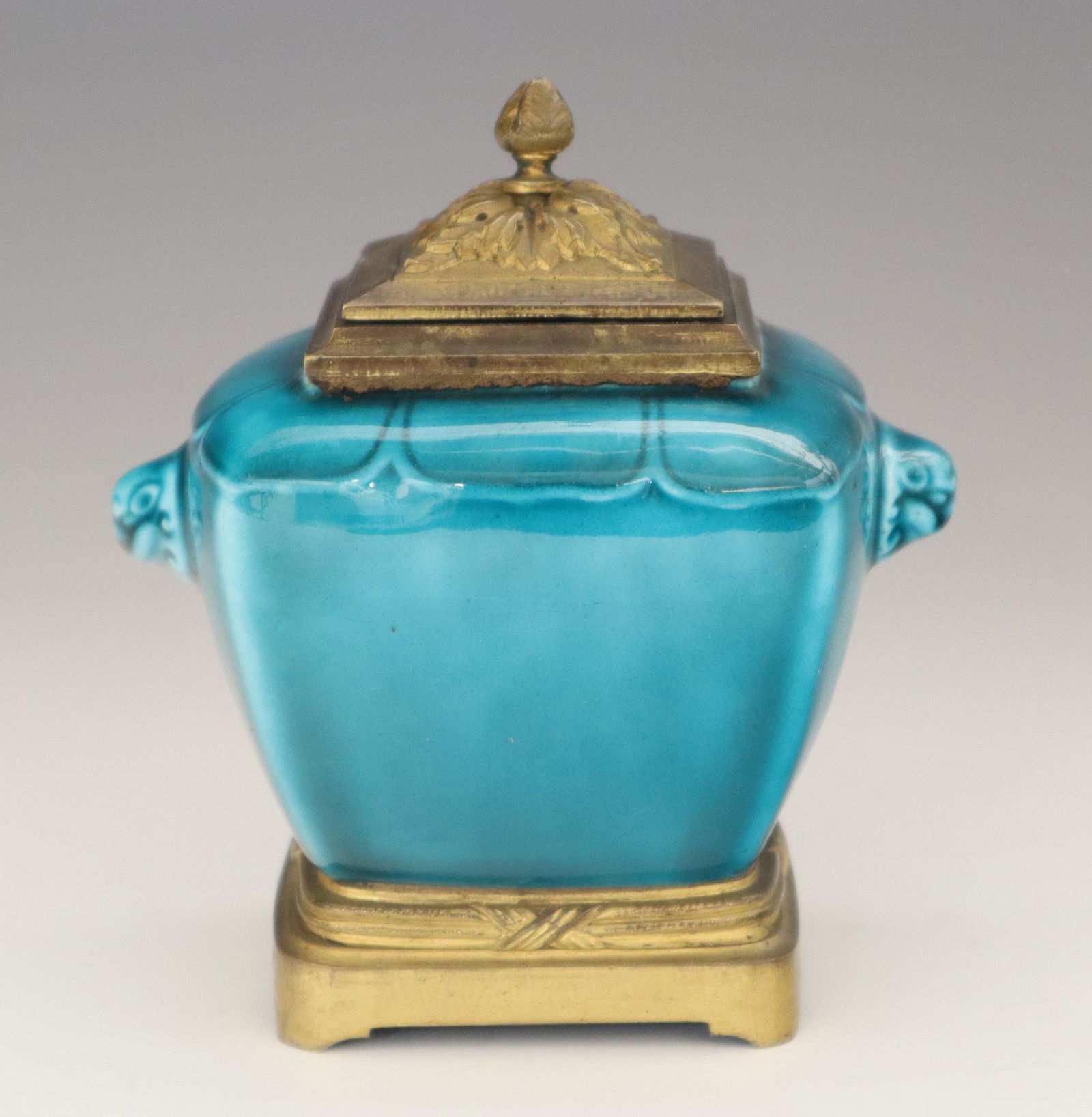 Th. Deck Inkwell: A 19th Century Theodore Deck Glazed Earthenware Inkwell. Chinoiserie style vessel is covered in a vibrant turquoise blue glaze overall, with mask motifs at either side, and bronze mounts. Marked "TH.