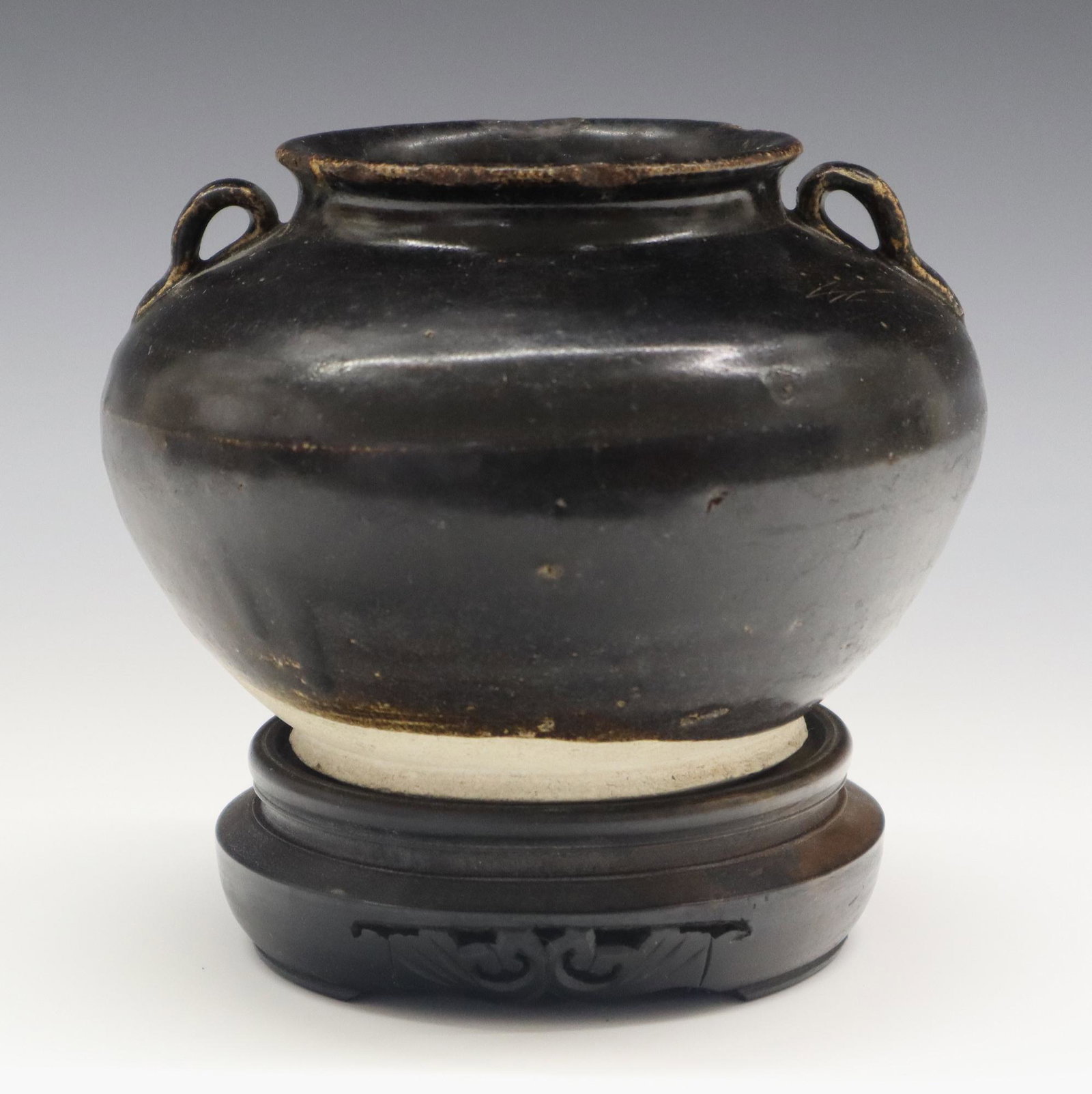 10th Century Chinese Pottery Vase: A 10th Century Chinese Pottery Vase. Cizhou ware bulbous vessel is covered, almost entirely with a dark brown/black glaze and consists of a slightly flared rim, small handles at either side, rounded s
