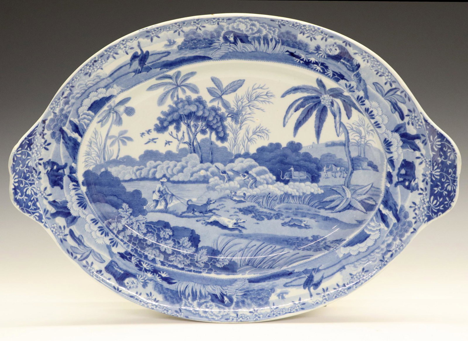 Clews Indian Sporting Series Stand: A 19th Century James & Ralph Clews "Indian Sporting Series" Stand. English oval blue and white transferware tureen stand, or underplate, with "Shooting at the Edge of the Jungle" scene at the well, co