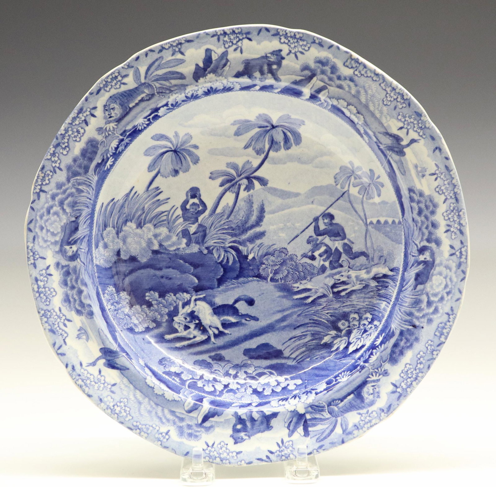 Spode Indian Sporting Series Soup Bowl: A 19th Century Spode "Indian Sporting Series" Soup Bowl. Round blue and white transferware soup bowl is decorated with motif entitled "Chase after a Wolf" and is surrounded by a border containing an e