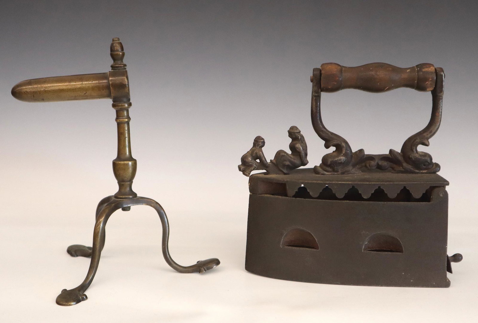 2 Clothes Ironing Tools: A 19th century Brass Gophering Iron stand and a coal Iron with children on a teeter totter figural latch. Some wear. Up to 9 1/2" high. ESTIMATE $50-75