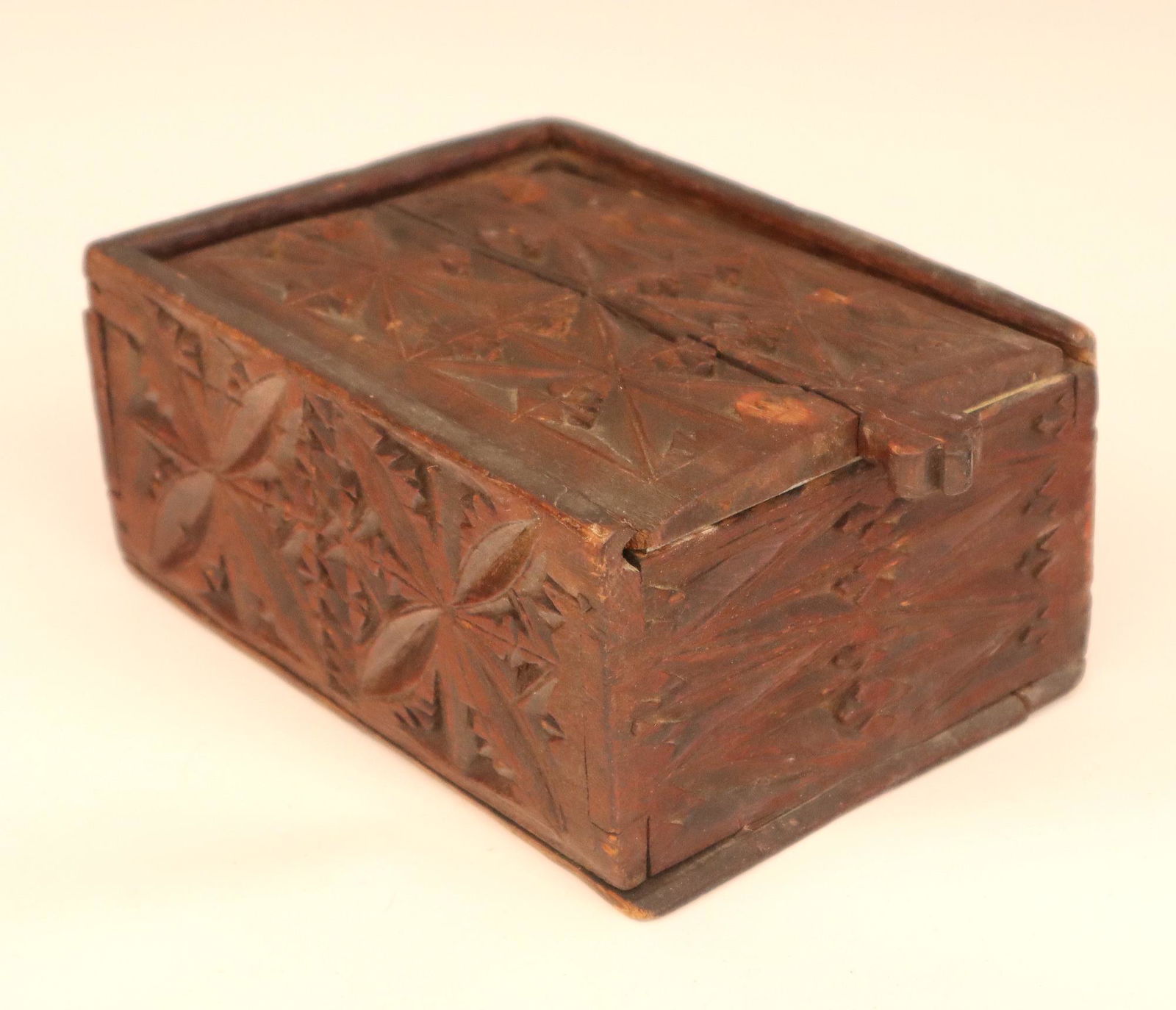 Early Slide Lid Box: A 18th/19th century Pine slide lid storage box with Lolli-pop handle and chip carved decoration. Old Brown paint with wear and minor damage, metal plate added to underside of cover. 8 1/4 x 5 1/2 x 3