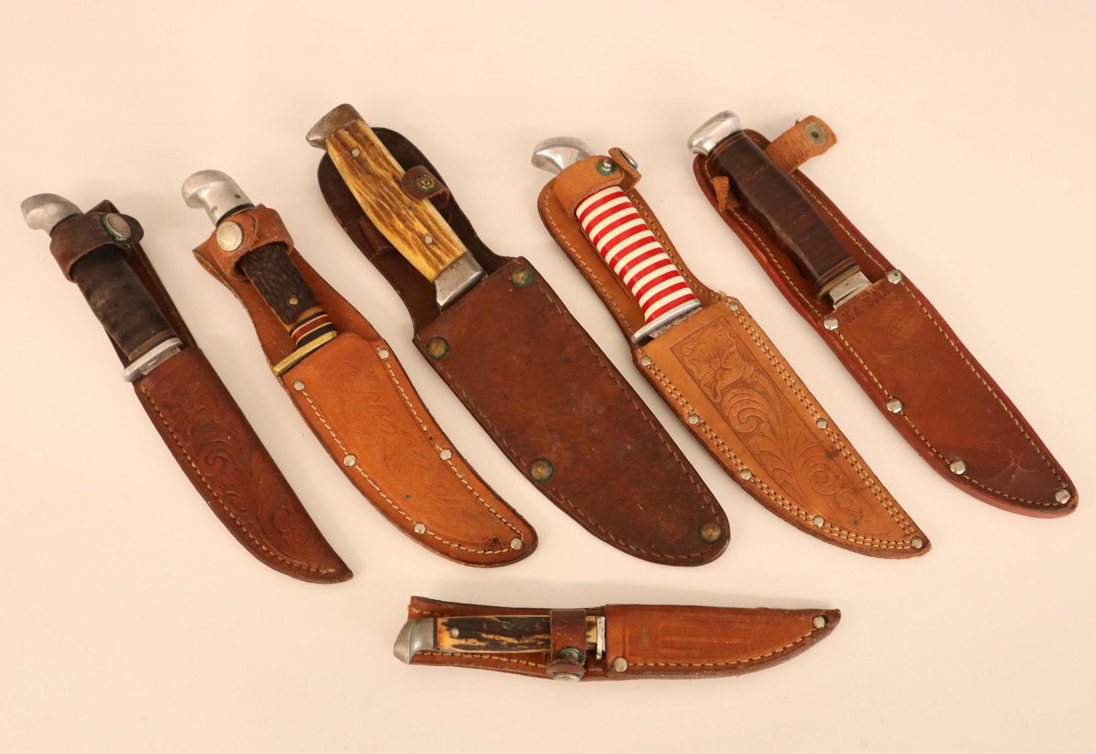 6 Vintage Hunting Knives: Six Vintage hunting knives with tooled leather sheaths. Makers include Schrade, Ka-Bar, Hollinger, Western, Case and Leirowier. Some wear to blades and sheaths. Up to 10" long. ESTIMATE $100-150
