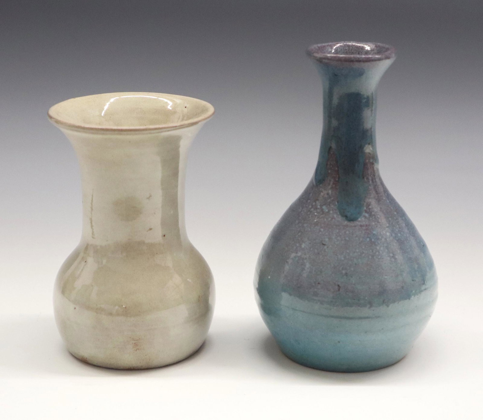 2 Art Pottery Vases: Two Art Pottery vases. Includes a "Pine Ridge Sioux" 5" vase by E. Irving with a flared rim and a "North State" 6 1/2" bottle form vase in Blue. Incised/impressed marks. Slight wear. ESTIMATE $100-150