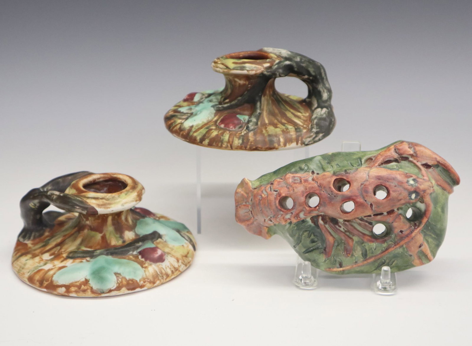 3 Weller Art Pottery Pieces: Three 20th century Weller Art Pottery pieces. Includes a pair of "Warwick" candlesticks and a "Muscota" Lobster form flower frog. Impressed and printed marks. Minor wear. Approx. 3" high. ESTIMATE $50
