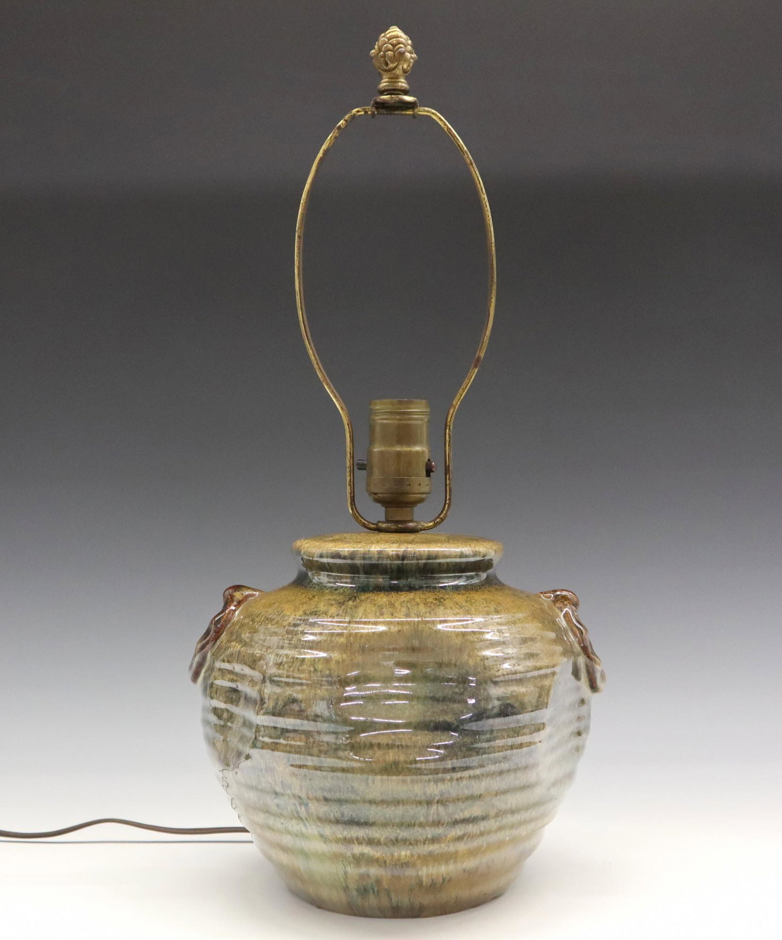 Fulper Table Lamp: A 20th century Fulper Art Pottery table lamp. Ring handle design with "dents" in body. Impressed marks. Slight wear, no shade. Base 7" high, 18" overall. ESTIMATE $200-300