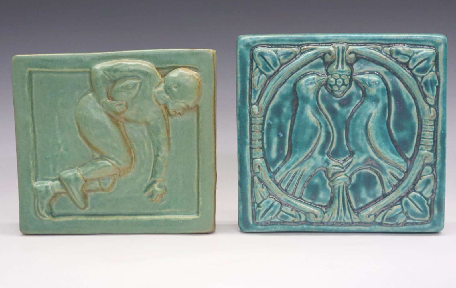 2 Pewabic Pottery Tiles: Two Pewabic Pottery tiles. Includes a 1997 tile with a vintage football player and a 2017 tile with birds. Impressed marks. Slight wear. Approx 7 1/4" square. ESTIMATE $100-150