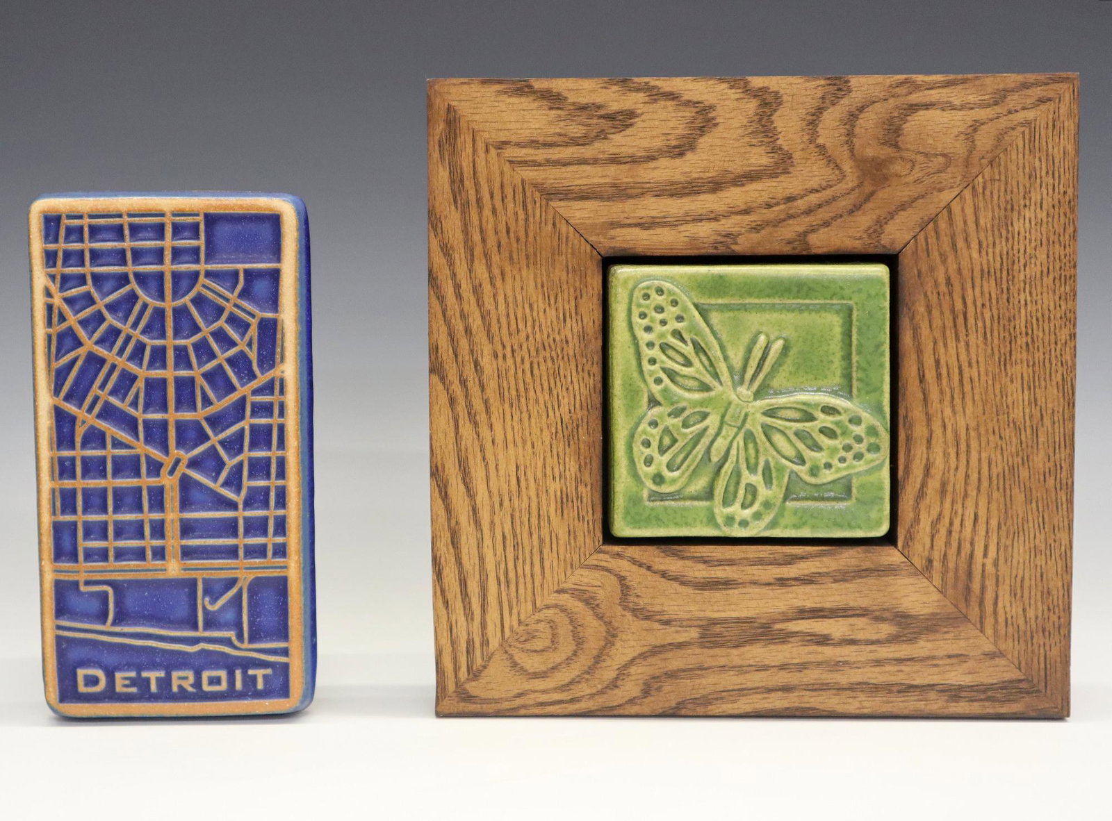 2 Pewabic Pottery Tiles: Two Pewabic Pottery tiles. Includes a 2017 Detroit tile with geometric design and a 2017 tile with a butterfly (framed 9" square). Impressed marks. Slight wear. Approx 4 x 7" and 4 3/4" square. ESTIMA