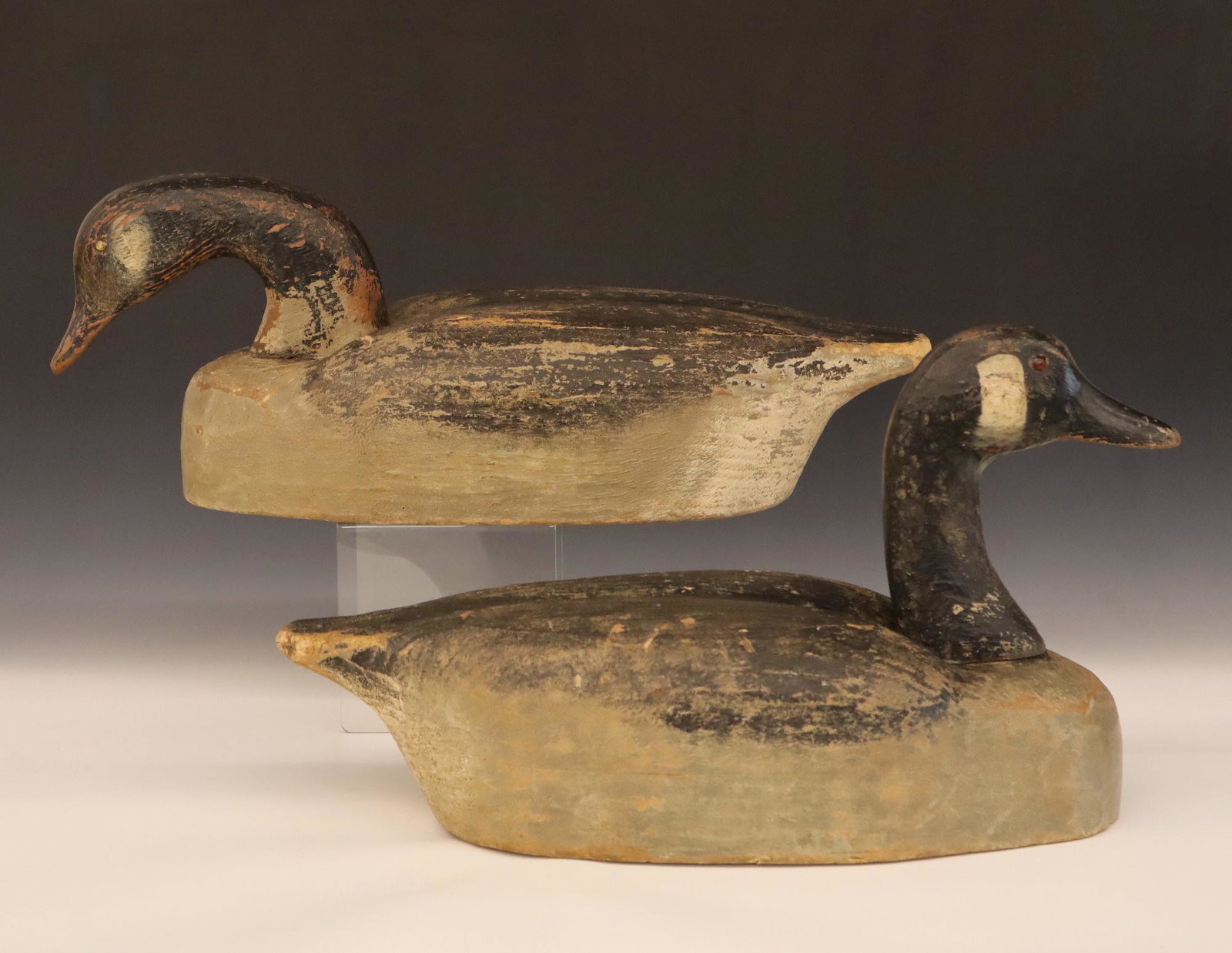 Pair of Herter: A Pair of 1950's Herter's Canada Goose Decoys. Carved Balsa bodies with glass eyes and original paint. Some damage, one with a loose neck and some wear to paint. Up to 20 1/2" long. ESTIMATE $100-200