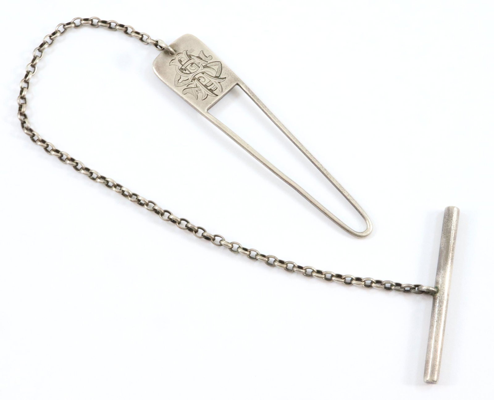Tiffany Sterling Cloak Clasp: A Tiffany & Co. Sterling Silver cloak clasp. One end fits over a button and the other into a button hole. Marked with the "Tiffany & Co. 4469 M 2920" mark. Monogramed and dated 1879. Slightly mis-shap