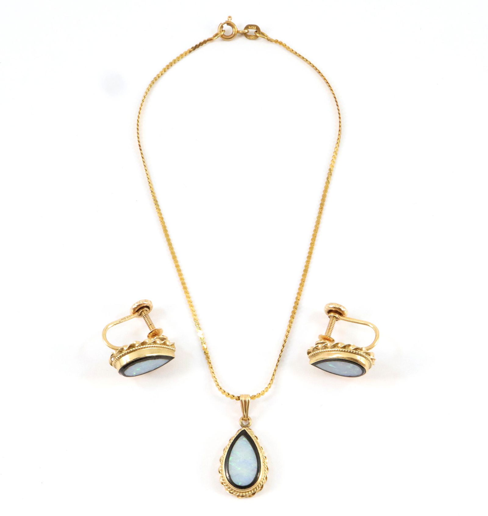 14k Gold & Opal Parure: A 14k Gold & Opal Parure. Consisting of a pair of screwback earrings and a pendant suspended from a 9" 14k chain. 6.5 grams total weight. Slight wear. ESTIMATE $100-200
