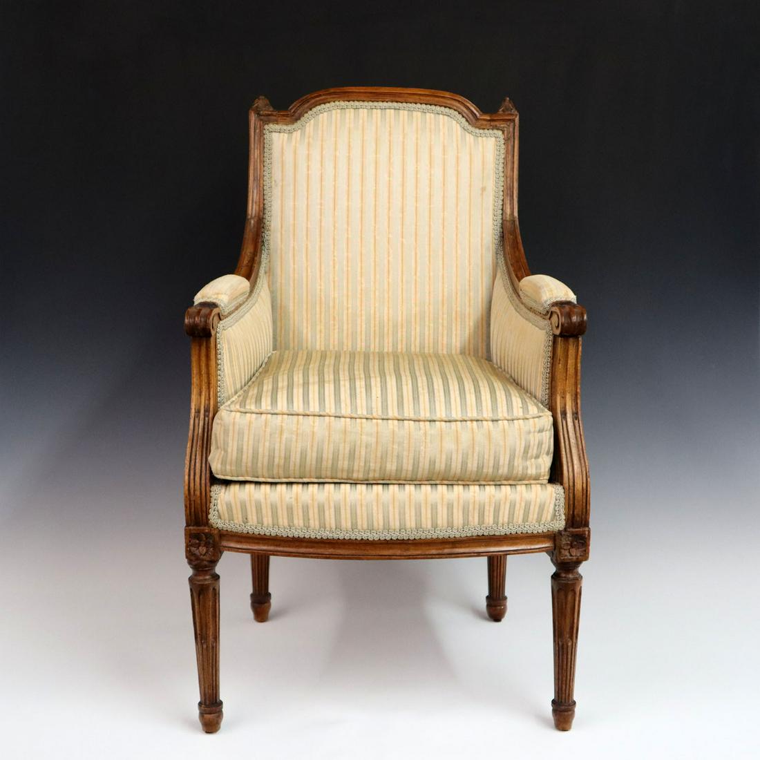 French Child's Bergere: A late 19th century French Louis XVI style Walnut Child's Bergere, carved reeded tapering legs and finials. Old worn upholstery, older finish with minor wear and old repair to the arms. 27 1/2" high. 