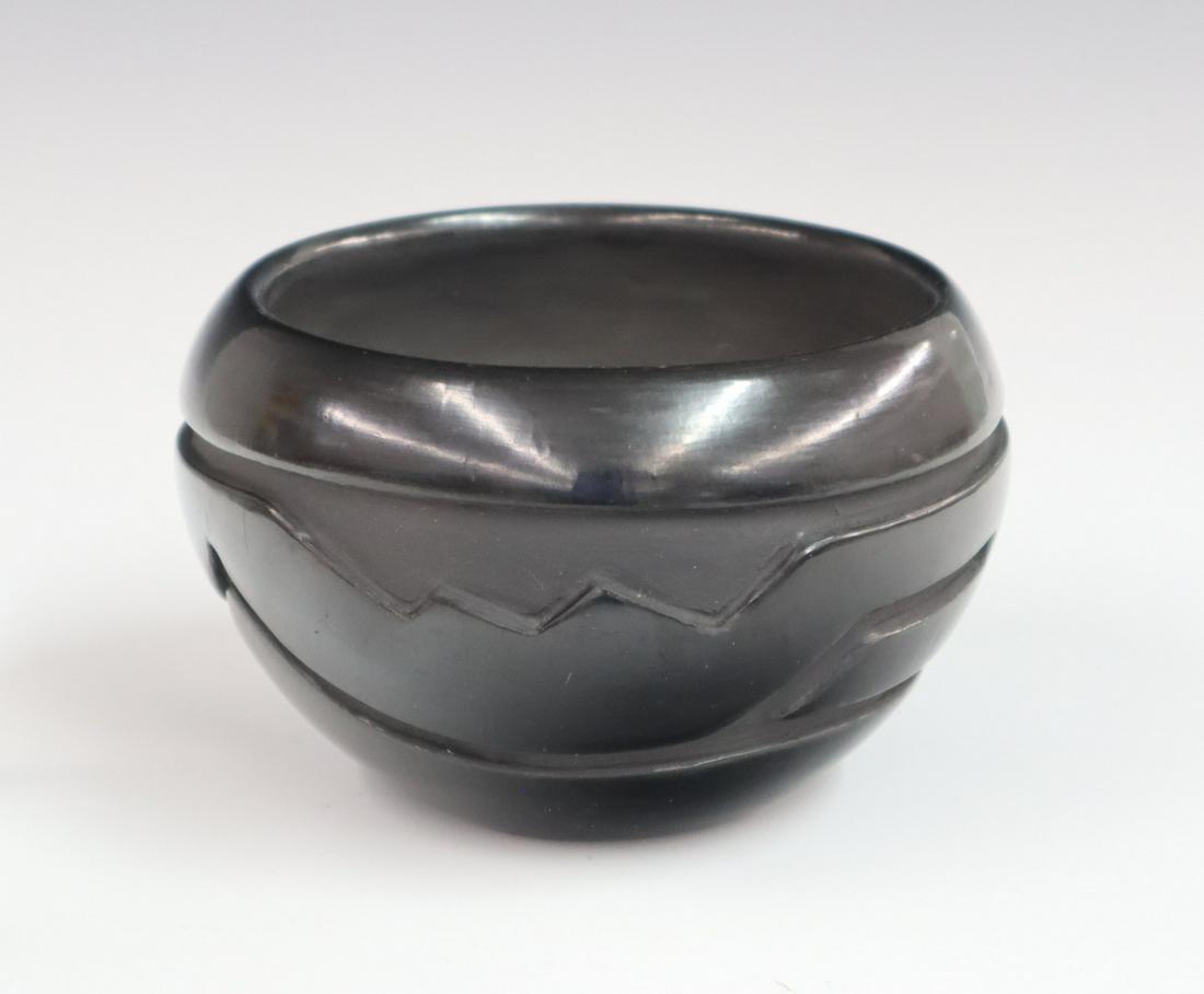 Santa Clara Bowl: A late 20th century Santa Clara Pueblo blackware bowl, with incised band depicting a water serpent. Signed "Mary Cain Santa Clara Pueblo" in pencil. Some minor scratching at base. 3 1/2" high. ESTIMAT