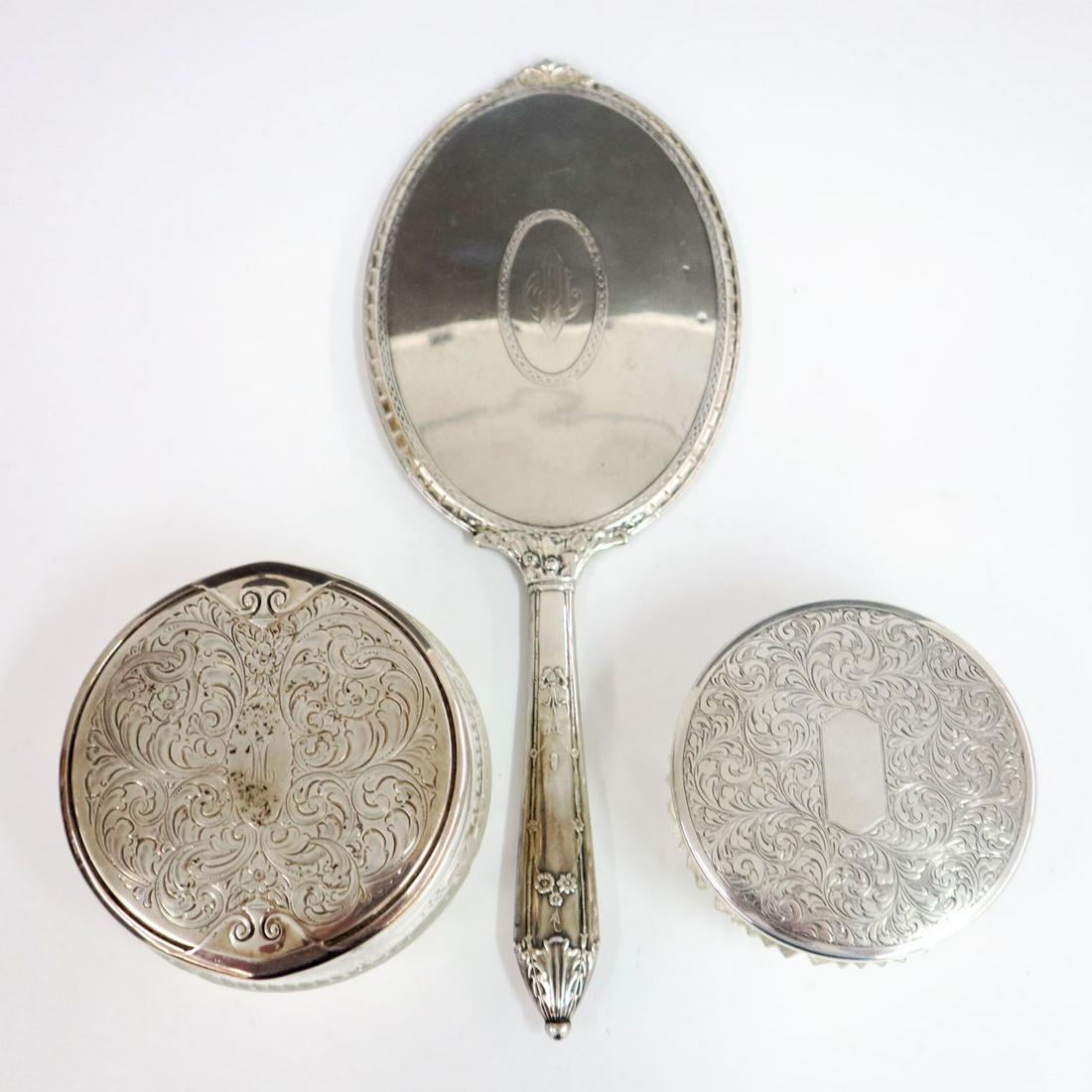 3 Sterling Dresser Items: Three early 20th century dresser items, two cut glass powder jars with Sterling silver lids and a Sterling silver hand mirror. Minor wear to each piece, some scratches to mirror, one jar and mirror wi