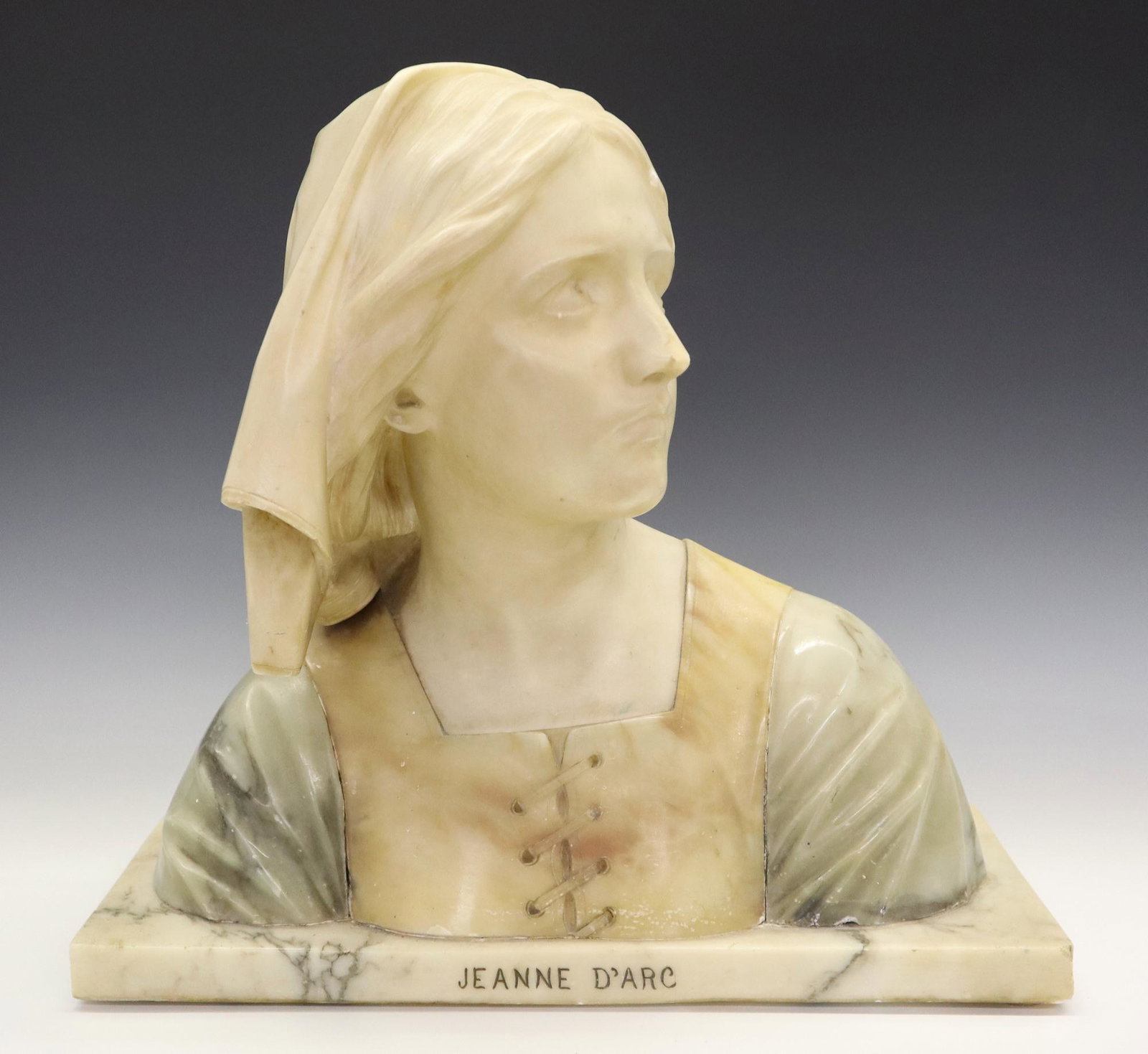 Prof. G. Bessi Alabaster Joan of Arc Bust: Prof. Giuseppe Bessi, Italian, 1857-1922. An early 20th century French Alabaster bust entitled Jeanne D'Arc. Carved from two color Alabaster with her head turned to her left gazing skyward. Incised si