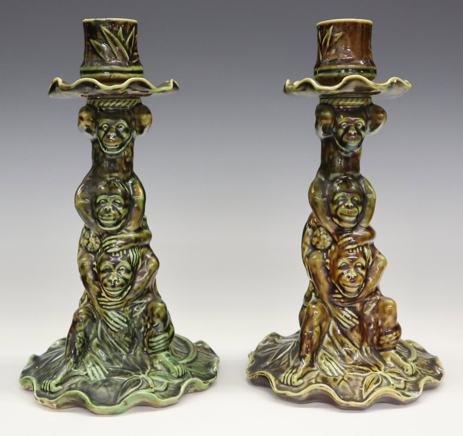 Pr Minton's Majolica Candlesticks: A pair of late 19th century Minton's Majolica candlesticks. Molded bodies with Monkeys and foliage in a Green/Brown mottled glaze. Impressed marks. Minor wear. Each 8 1/2" high. ESTIMATE $100-200