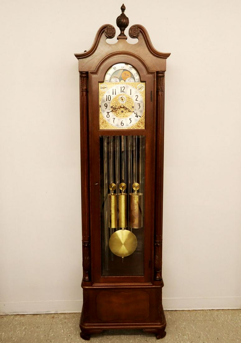 Herschede Grandfather Clock: A late 20th century Herschede nine tube three train Mahogany Grandfather Clock. Brass face and weights, delivered January 1970. Minor finish wear. Tubes, weights, and pendulum are slightly tarnished. 