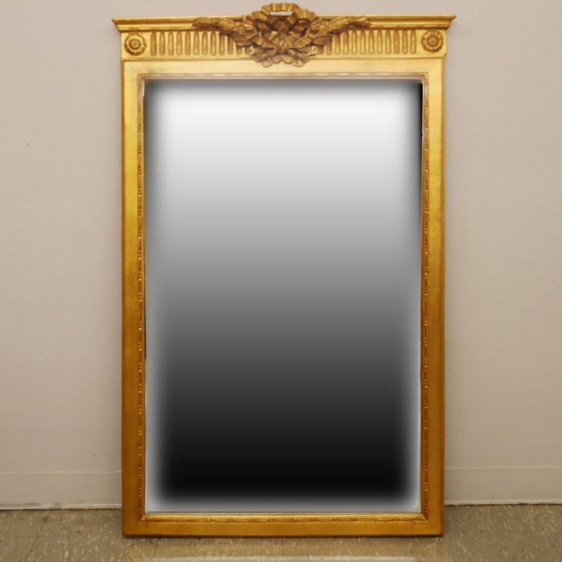 Louis XVI Style Mirror: A late 20th century gilded Louis XVI style mirror. Decorated with floral rosettes at the top corners and stylized ribbons at the crest. Minor wear. 50 1/2" high. ESTIMATE $100-200
