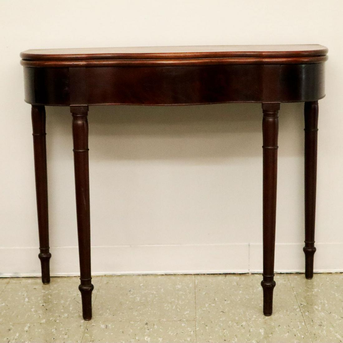 American Mahogany Games Table: An early 19th century American mahogany turned leg games table. Serpentine front, with a single gate leg support when open. Poplar and pine secondary woods, Mid-Atlantic states in origin. Older refini