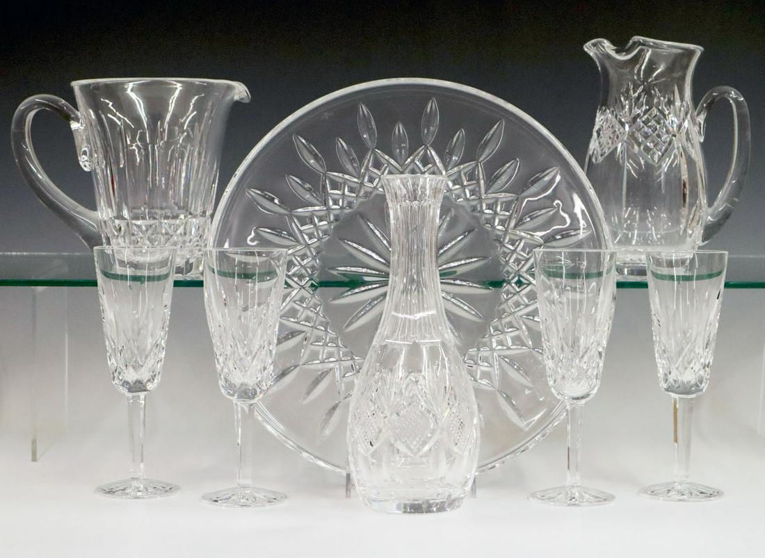 8 pieces of Waterford Crystal: Eight pieces of 20th century Waterford crystal. Including a 12 1/2" cafe tray, a 9" carafe, four champagne flutes and two pitchers. Very minor wear to bases. Up to 7 3/4" high. ESTIMATE $100-200