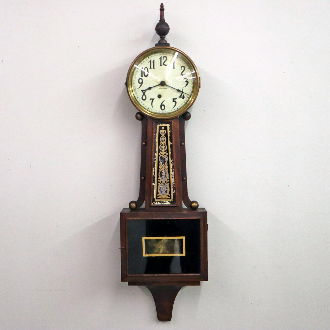 Ingraham Banjo Clock: An early 20th century Ingraham Banjo Clock. Spring driven movement, mahogany case with brass ornamentation, and reverse painted throat and bottom glass. Original finish with wear and crazing. Some fla