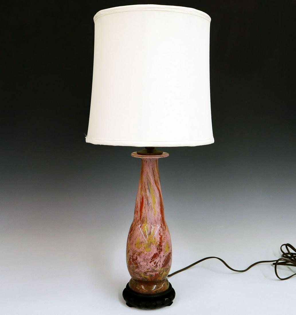 Art Glass Lamp: An Early 20th Century Art Glass Lamp. Rose colored moss agate lamp with flecks of yellow, gold, and copper on a footed body with carved wooden base. Includes an alabaster colored fabric shade. Replace