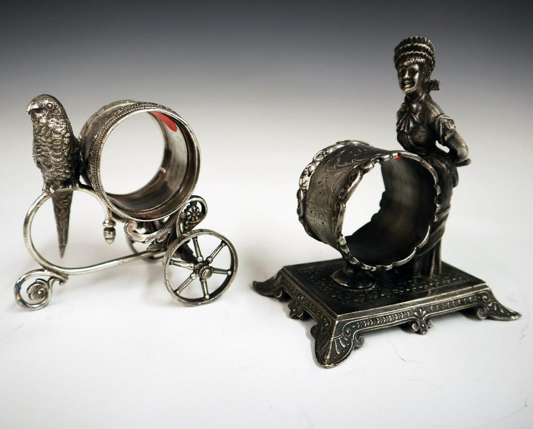 2 Silver Plate Napkin Rings: Two Early 20th Century Silver Plate Figural Napkin Rings. Including 1 by Rogers, Smith, & Co. that depicts an Edwardian woman shown with her hands clasped behind her back and 1 unmarked piece that dep