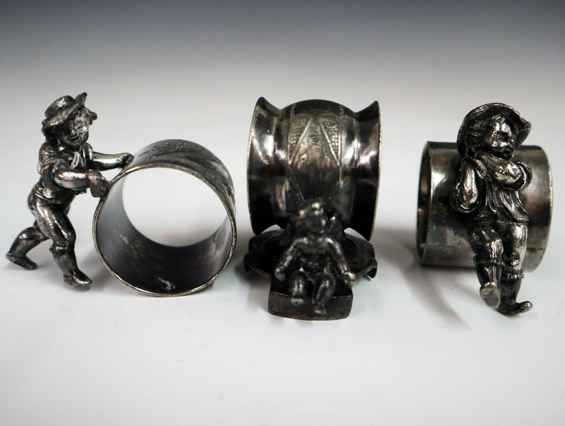 3 Silver Plate Napkin Rings: Three Early 20th Century Silver Plate Figural Napkin Rings. Including 1 unmarked which depicts a boy carrying a load over his shoulder, 1 by Meridian Silver Plate Co. that depicts a boy rolling the ri